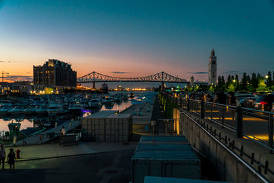 Bridge over river in city at dusk