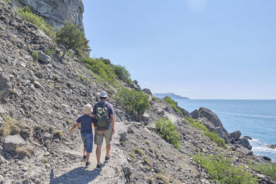 A boy and his grandfather hiking on the scenic golitsyn trail. national botanical reserve new world