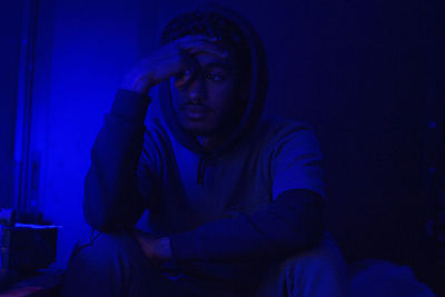 Young man standing in darkroom