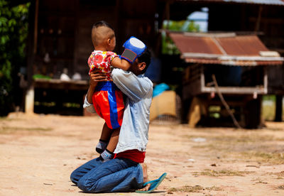 Cheerful of father and son practicing boxing on field