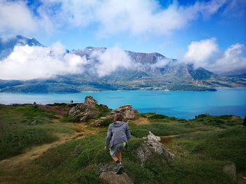 Rear view of woman on mountain against sky