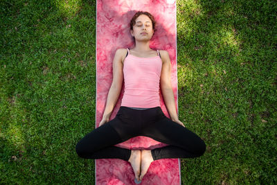 Full length of young woman sitting on grass