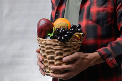 Midsection of man holding basket