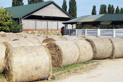 Hay bales on field by building