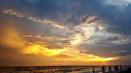 Scenic view of sea against dramatic sky during sunset