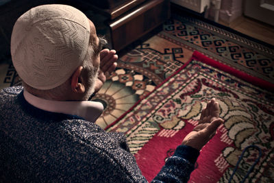 High angle view portrait of boy sitting on carpet