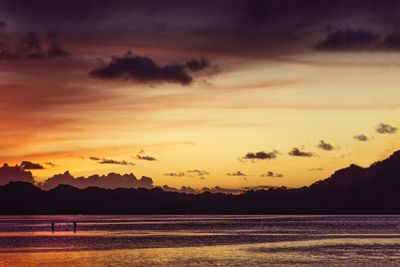 Scenic view of sea against dramatic sky during sunset