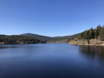 Scenic view of lake against clear blue sky