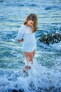 Sea waves splashing on woman at beach