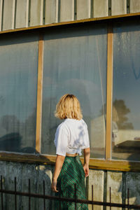 Rear view of woman standing by railing