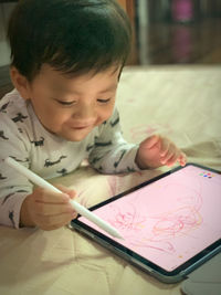 Cute boy holding paper at home