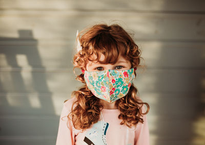 Young girl looking wearing floral homemade face mask outside