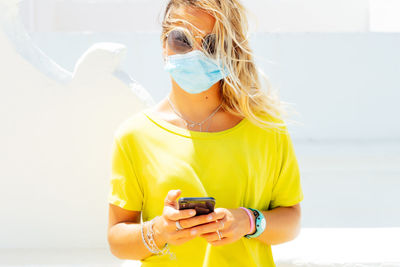 The young woman with the mask is thinking while waiting for a call on