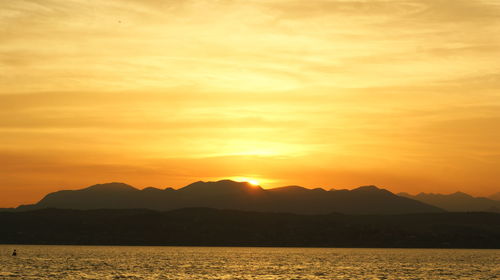 Scenic view of silhouette mountains against romantic sky at sunset