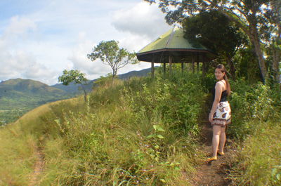 Full length of woman walking on grass against sky