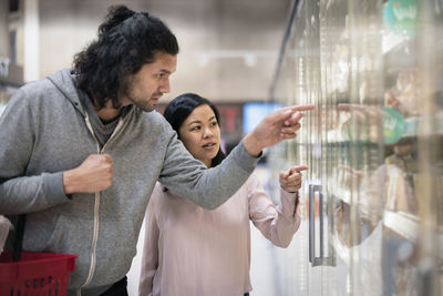 Young couple shopping during inflation in supermarket