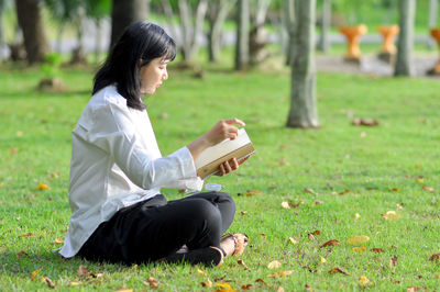 Woman sitting on grass in field