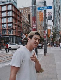 Young man smiling on street in city