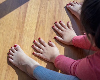 High angle view of hands and woman lying on floor