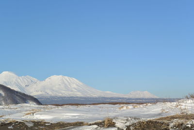 Scenic view of snowcapped mountains against clear blue sky