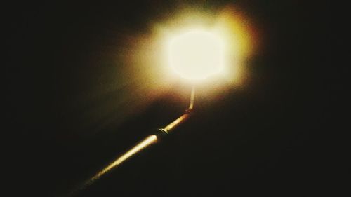 Low angle view of illuminated light bulb at night