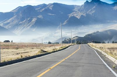 Road by mountains against sky