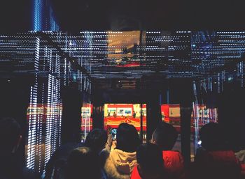 People in illuminated building at night