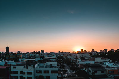 High angle view of buildings against clear sky at sunset