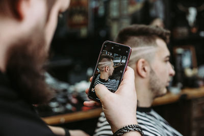 Midsection of man using mobile phone outdoors