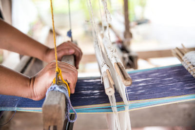 Close-up of person working on handloom