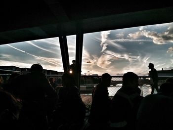 Panoramic view of silhouette people in front of sky during sunset