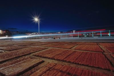 Light trails on beach against sky at night