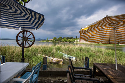 Chairs on agricultural field against sky