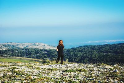 Woman standing on mountain against sky