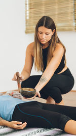 Portrait of young woman sitting on bed at home