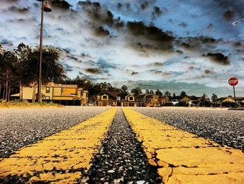 Surface level of road against cloudy sky