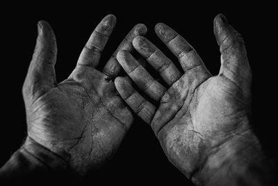 Cropped image of person with messy hands against black background