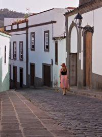 Rear view of woman standing outside house