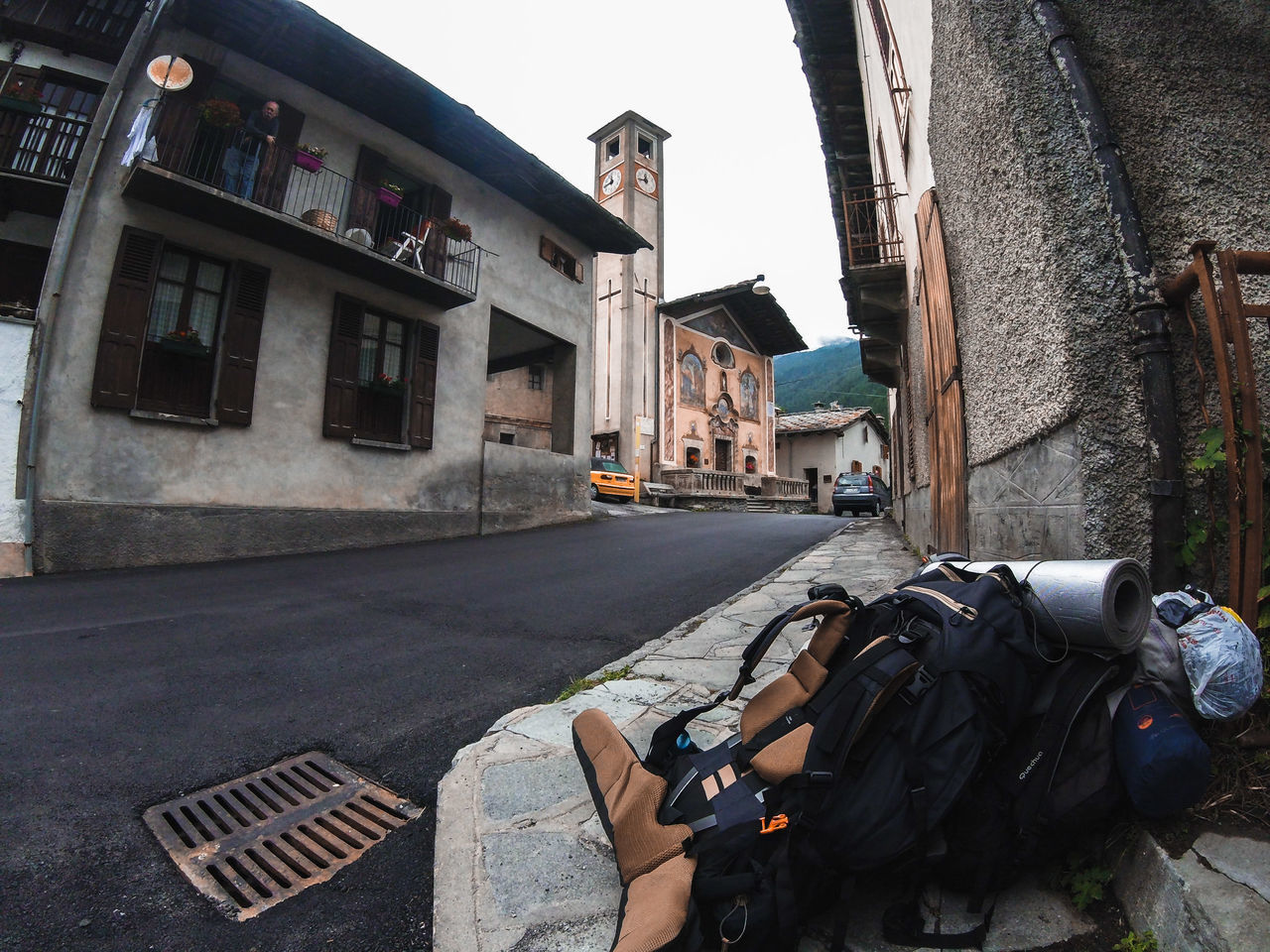 MAN PHOTOGRAPHING BY BUILDINGS ON ROAD