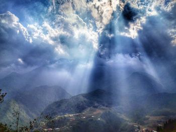 Scenic view of rainbow over mountains against sky