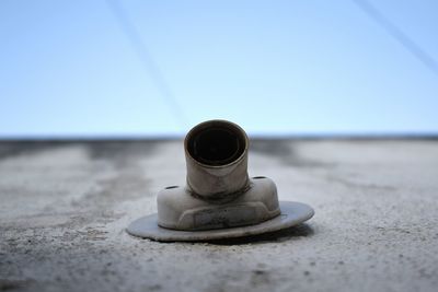 Close-up of metallic structure on beach against clear sky