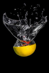 Close-up of yellow splashing water against black background