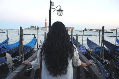 Rear view of woman in sea against sky