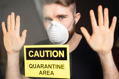 Portrait of man wearing mask with text on glass