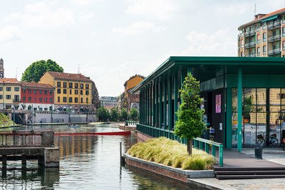 River amidst buildings in city against sky