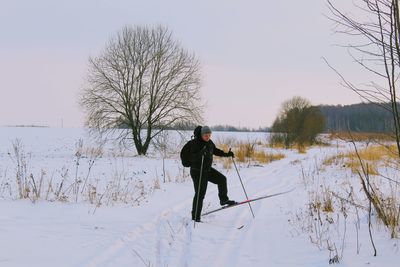 Rear view of man on snow field against sky