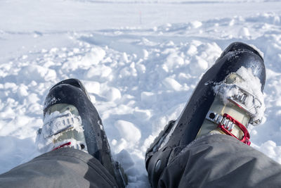 Low section of man sitting on snow