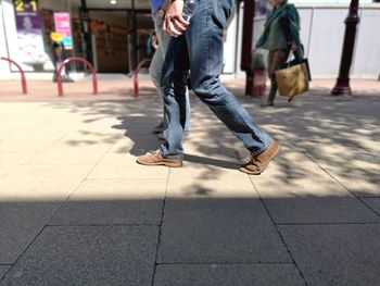 Low section of men walking on street