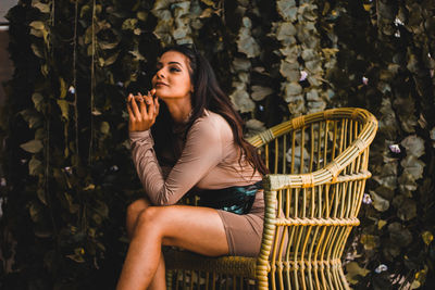 Smiling woman sitting on wicker chair