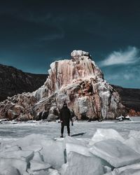 Rear view of man standing on snow covered mountain